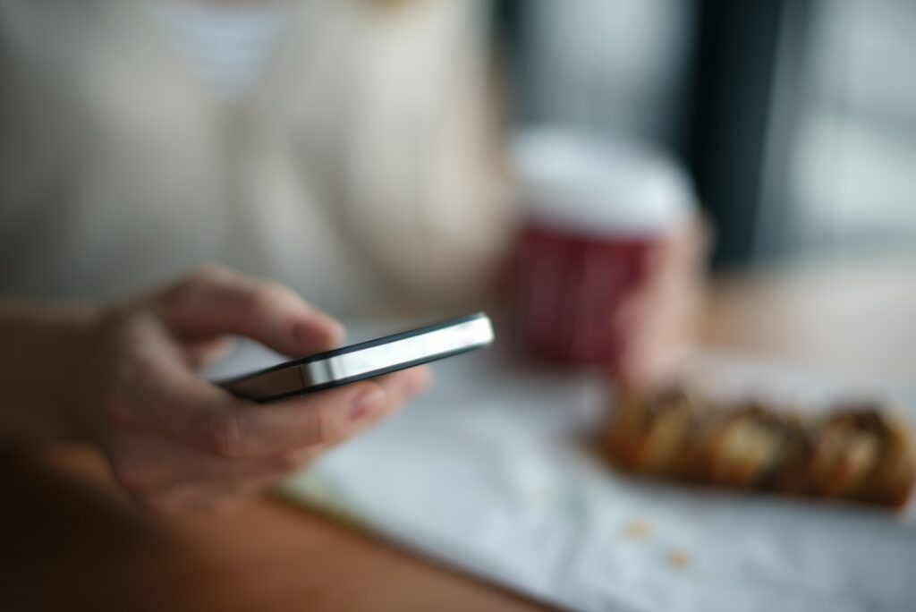 selective focus photography of person holding gray phone